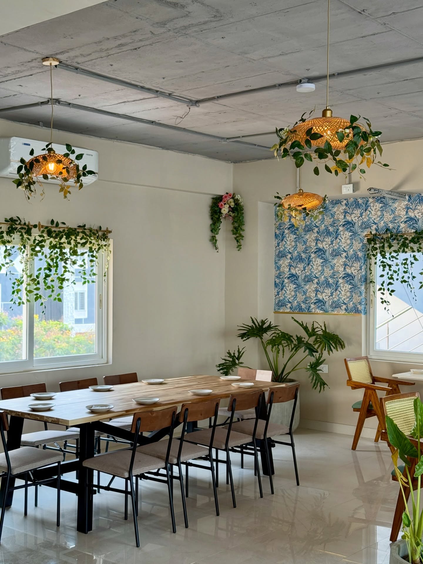Communal dining tables beneath hanging plants at Kami Hyderabad